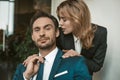 Passionate couple flirts at work. Office romance concept. Caucasian man and woman in love wearing formalwear. Man looks Royalty Free Stock Photo