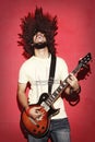 Passionate guitarist screaming with beautiful long curly hair pl Royalty Free Stock Photo