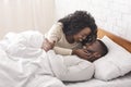 Romantic african couple kissing in bed, enjoying spending time together