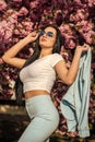 Passionate about spring. Clothes shop. Gorgeous fancy girl outdoors. Woman fancy sunglasses in spring flower bloom. Girl