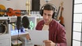Passionate young hispanic guy, a serious male musician concentrating on singing a soulful song at the music studio, living his