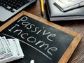 Passive income inscription on the board and bundle of bills. Royalty Free Stock Photo