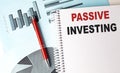 PASSIVE INVESTING word on wooden cubes with pen and magnifier