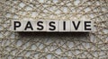 PASSIVE - a word on wooden cubes on the background of an openwork napkin. business concept