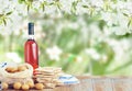 Passover celebration concept. Matzah, red kosher and walnut on wooden vintage table table in front of spring blossom tree garden