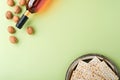 Passover celebration concept. Matzah, red kosher wine and walnut. Traditional ritual Jewish bread on light green background.