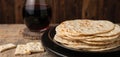 Passover celebration includes matzah and red wine. Unconsecrated cracker flatbreads served with kosher wine for Seder meal. Royalty Free Stock Photo