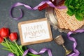 Passover holiday concept matzoh, photo frame and tulip flowers on dark background. Royalty Free Stock Photo
