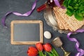 Passover holiday concept seder plate, matzoh and chalkboard on dark background. Royalty Free Stock Photo