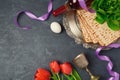 Passover holiday concept seder plate, matzoh and tulip flowers on dark background. Top view Royalty Free Stock Photo