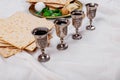 Passover matzoh jewish holiday bread, four glasses kosher wine over wooden table