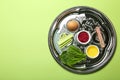 Passover Seder plate keara with symbolic meal on green background, top view. Pesah celebration Royalty Free Stock Photo