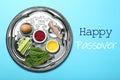 Passover Seder plate keara with symbolic meal on blue background, top view. Pesah celebration