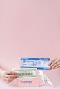 Passport, dollars and air ticket in woman hand on a pink background. Travel concept, copy space Royalty Free Stock Photo