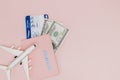 Passport, dollars, plane and air ticket on a pink background. Travel concept, copy space Royalty Free Stock Photo