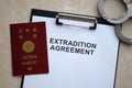 Passport of Japan and Extradition Agreement with handcuffs on table