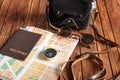 Passport with map, compass, sunglasses and photo camera on wooden table Royalty Free Stock Photo