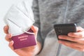 Passport pandemic vacation concept: Close up of man holding a passport, ffp2 protection mask and smartphone, Ã¢â¬ÅReisepass Passport