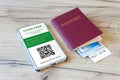 passport and a smartphone with a Certificate of Vaccination against Covid-19 disease are arranged on a wooden table. all the