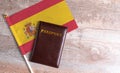 Passport and a Spain flag on a wooden background