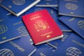 Passport of Spain on the pile of passports of other countries. Immigration, citizenship, travel and tourism concept