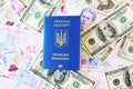 Passport of Ukraine, a document for traveling abroad against the background of banknotes of the national currency and dollars, top Royalty Free Stock Photo