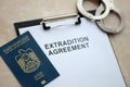 Passport of United Arab Emirates and Extradition Agreement with handcuffs on table