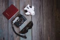 A passport, vintage camera, small aircraft and sunglasses on wooden table