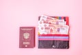 Passport and Wallet with five thousand Russian rubles on a pink background. Flat lay, top view