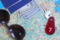 Passports sunglasses money and room key number seven on map. Travel concept