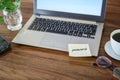 Password written on a sticky note and taped to the laptop on a wooden desk, dangerous security gap, copy space Royalty Free Stock Photo