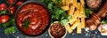 Pasta background. Pasta rigatoni, tomato ketchup sauce, olive oil, spices, parsley, and fresh tomatoes on a dark slate, stone or