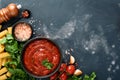 Pasta background. Pasta rigatoni, tomato ketchup sauce, olive oil, spices, parsley, and fresh tomatoes on a dark slate, stone or