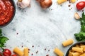 Pasta background. Pasta rigatoni, tomato ketchup sauce, olive oil, spices, parsley, and fresh tomatoes on light grey old slate, st