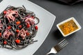 Pasta with black cuttlefish ink and small octopuses