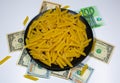 Pasta on a black plate under which lies money