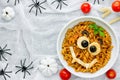 Pasta bolognese on Halloween party, fun recipe for kids to dinner or lunch, edible cute monster face from fusilli in sauce Royalty Free Stock Photo