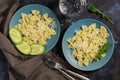 Pasta bow is sprinkled with cheese, rucola leaves, fresh cucumber, dark blue background. Royalty Free Stock Photo