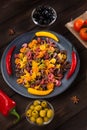 Pasta and burning peppers on a gray plate with tomatoes, sweet pepper, lemon, olives and olives on a wooden dark Royalty Free Stock Photo