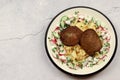 Pasta campanelle with liver pancakes and fresh salad on a white round plate on a light gray background Royalty Free Stock Photo