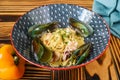 Pasta carbonara with sea food on blue plate isolated on black background side view Royalty Free Stock Photo