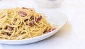 Pasta carbonara spaghetti with ham, bacon and fresh parmesan on the white plate in restaurant in Catania, Sicily, Italy Royalty Free Stock Photo