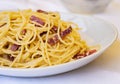 Pasta carbonara spaghetti with ham, bacon and fresh parmesan on the white plate in restaurant in Catania, Sicily, Italy Royalty Free Stock Photo