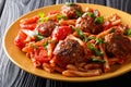 Pasta Casarecce recipe with meat balls, herbs and cheese in tomato sauce closeup on a plate. horizontal Royalty Free Stock Photo