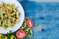 Pasta with cheese and vegetables on a white plate copy space top view bright blue background Royalty Free Stock Photo