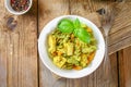 Pasta with chicken pieces and pesto sauce on an old wooden table. Royalty Free Stock Photo