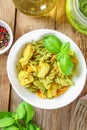 Pasta with chicken pieces and pesto sauce on an old wooden table. Royalty Free Stock Photo