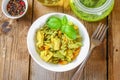 Pasta with chicken pieces and pesto sauce on an old wooden table. Royalty Free Stock Photo