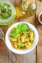 Pasta with chicken pieces and pesto sauce on an old wooden table Royalty Free Stock Photo