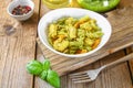 Pasta with chicken pieces and pesto sauce on an old wooden table. Royalty Free Stock Photo